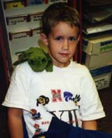 student with plush frog on his shoulder