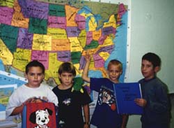 four children in front of a map
