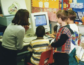 children and teacher around computer