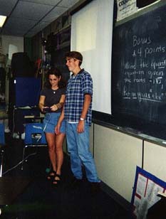 Two students standing in front of room.